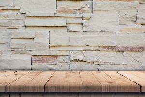 Empty wood table and pattern of decorative slate stone wall surface with copy space photo