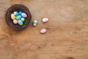 Colorful Easter Egg and nest on a rustic old wood background. Above view with copy space. photo