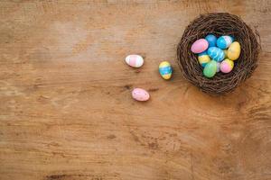 Colorful Easter Egg and nest on a rustic old wood background. Above view with copy space. photo