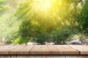 mesa de madera y fondo de jardín natural verde borroso con espacio de copia foto