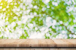green leaf bokeh blurred and wood table for nature background photo