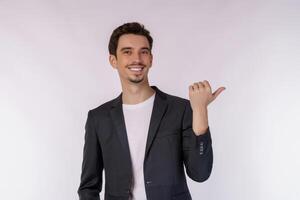 Portrait of young businessman pointing fingers at copy space isolated on white studio background photo