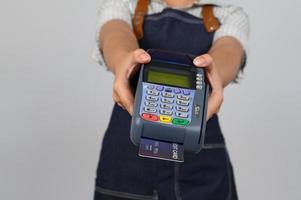 retrato de una joven asiática con uniforme de camarera posando con tarjeta de crédito foto
