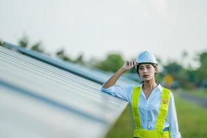 joven ingeniera asiática que trabaja con paneles solares en la estación foto