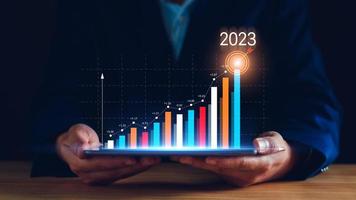 objetivos de marketing digital 2023. hombre de negocios que analiza el marketing de Internet en línea, la planificación empresarial de 2023, el aumento de los negocios, el análisis del mercado de valores en línea, el gráfico de acciones el próximo año, el comercio de acciones digitales foto