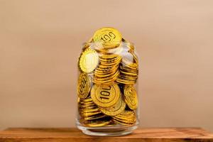 Saving gold. Saving money. Gold savings concept in a glass jar. Store gold in a glass jar. photo