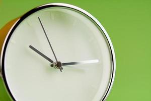 despertador sobre fondo verde, concepto de tiempo, foto de reloj