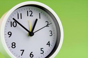 Alarm clock on green background, time concept, clock photo