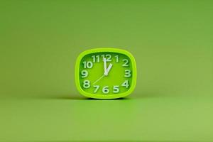 despertador sobre fondo verde, concepto de tiempo, foto de reloj