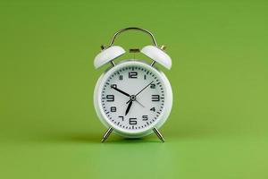 despertador sobre fondo verde, concepto de tiempo, foto de reloj