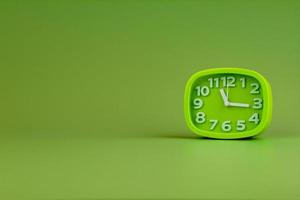 Alarm clock on green background, time concept, clock photo