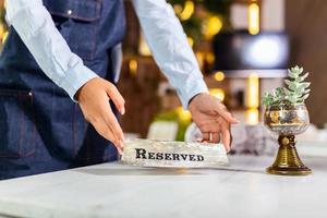 Elegante servicio de mesa de restaurante para recepción con tarjeta reservada. cartel de mesa reservada del restaurante foto