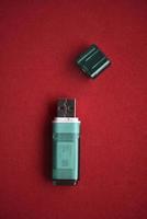 USB flash drive close-up on a red background. One USB flash drive with a lid. photo