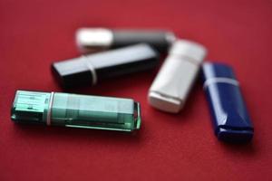 Colored flash drives on a red background. Storage of information. Flash drives in a pile. photo