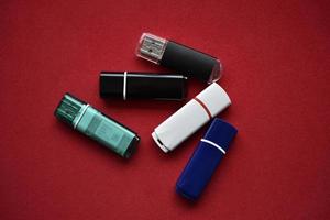 Colored flash drives on a red background. Storage of information. Flash drives in a pile. photo