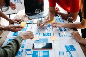 UX developer and ui designer brainstorming about mobile app interface wireframe design with customer breif and color code at office. photo