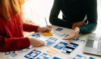 vista de cerca del equipo de desarrolladores de ui haciendo una lluvia de ideas sobre su proyecto con una computadora portátil, un teléfono inteligente y una tableta digital. agencia creativa de desarrollo digital. foto