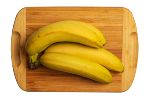 bando de bananas amarelas maduras frescas em uma placa de cozinha de madeira. png