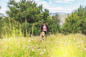 Adult woman walking with her dog in the mountains and having fun. photo