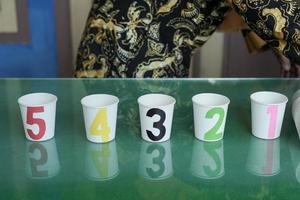 A game of numbers on glasses for early childhood using used glass media. There are numbers 1-5 with different color variants photo