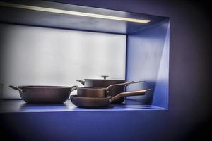 un bodegón minimalista con ollas y sartenes con fondo azul foto