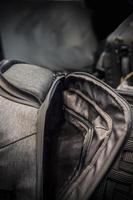 un detalle de una moderna mochila semiabierta de color gris oscuro foto