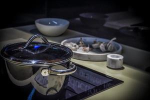 una cocina moderna con una olla de acero, platos y ajo foto