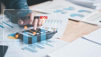 Analyst read business statistics chart reports, to analyze and improve corporate strategy, manage financial and marketing documents, update annual budget accounts, ROI, Return on investment photo
