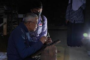 Los artesanos de keris están enseñando a los visitantes sobre el proceso de elaboración de keris en el taller. bantul, indonesia - 25 agosto 2022 foto