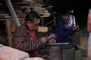 Los artesanos de keris están enseñando a los visitantes sobre el proceso de elaboración de keris en el taller. bantul, indonesia - 25 agosto 2022 foto