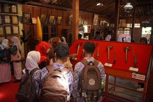 visitantes mirando una colección de kerises en una galería. bantul, indonesia - 25 agosto 2022 foto