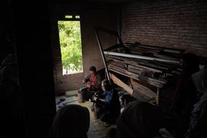 Los artesanos de keris están enseñando a los visitantes sobre el proceso de elaboración de keris en el taller. bantul, indonesia - 25 agosto 2022 foto