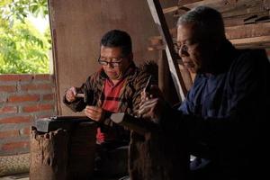 artesanos de keris en el taller, en el proceso de elaboración de keris. bantul, indonesia - 25 agosto 2022 foto