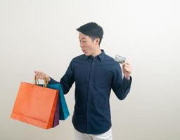 portrait young Asian man holding credit card and shopping bag photo