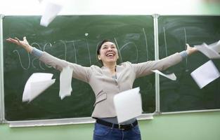 Happy teacher scatters papers before the holidays. photo