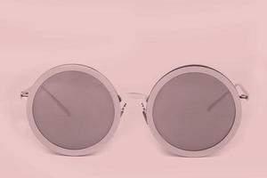 Pink sunglasses on a pink background. photo