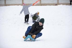 niños en invierno. los amigos de los muchachos están andando en trineo. foto