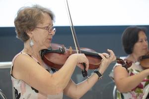 Belarus, Gomil, June 25, 2021. Public event on the street. An elderly woman plays the violin. photo