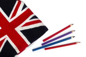sombrero de punto de invierno con un patrón de la bandera del Reino Unido y lápices de colores sobre un fondo blanco. foto