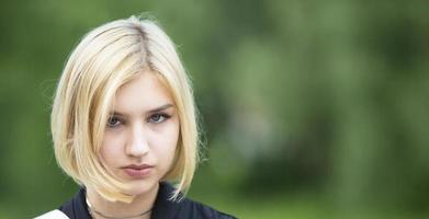 Blonde face on a green background. Seventeen year old girl. photo