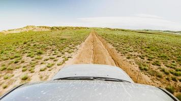 POV four-wheel-drive car on gravel dirt road in caucasus. Discovery and adventure travel concept. photo