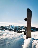 snowboard contra el cielo azul y las montañas cubiertas de nieve en europa, cáucaso foto