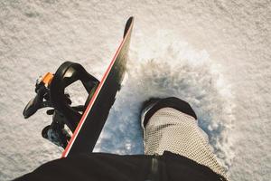 Unrecognized snowboarder walk on powder day on fresh snow with snowboard to freeride hilltop photo