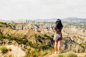 Wide panoramic view woman standing on viewpoint and looking over rocky landscape in VAshlovani national park taking photo capture travel adventure