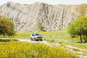 Front view 4WD on muddy off-road in wild nature outdoors on adventure extreme tour in caucasus mountains in hot day