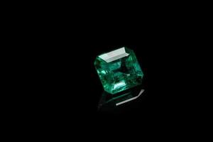 Macro mineral Emerald gemstone faceted on black background photo