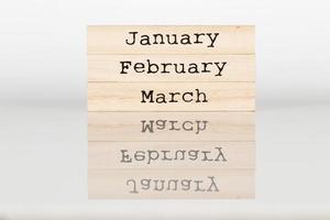 cubo de madera con la inscripción enero, febrero, marcha sobre un fondo blanco foto