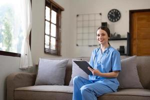 Portrait of a young Asian nurse or caregiver at home.Concept healthcare, profession, people and medicine photo