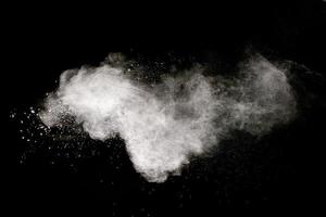 White powder explosion cloud against black background.White dust particle splash. photo