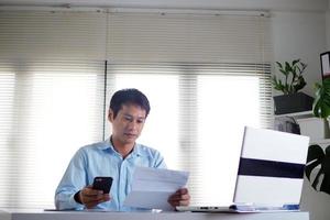 los hombres usan teléfonos inteligentes para pagar facturas a través de aplicaciones. foto